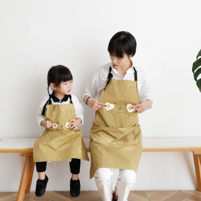 Grembiule impermeabile genitore-bambino con sorriso sull'uovo fritto