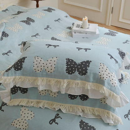 Trapunta con fiocco a farfalla in puro cotone garzato e nappe morbide