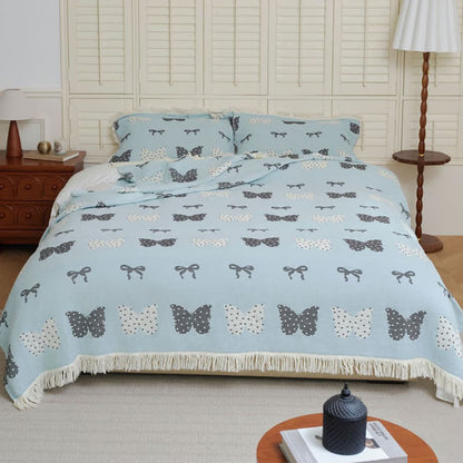 Trapunta con fiocco a farfalla in puro cotone garzato e nappe morbide