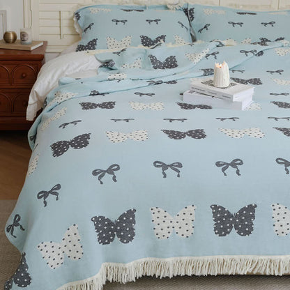 Trapunta con fiocco a farfalla in puro cotone garzato e nappe morbide