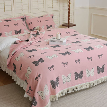 Trapunta con fiocco a farfalla in puro cotone garzato e nappe morbide