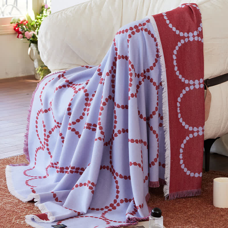 Coperta reversibile con motivo a cerchi e nappe - image 1