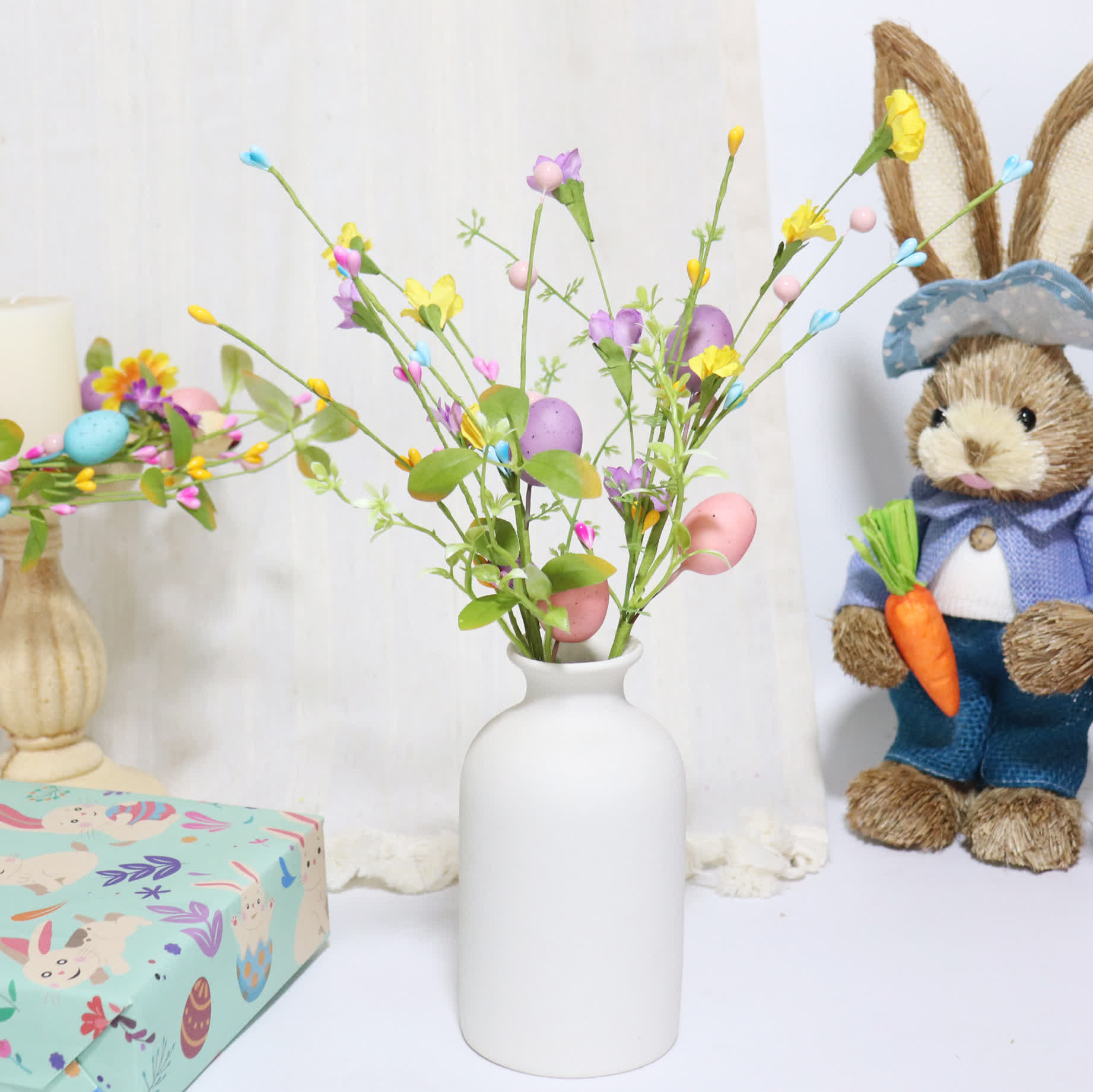 Ramo di uova di Pasqua con foglie verdi e fiori - image 0