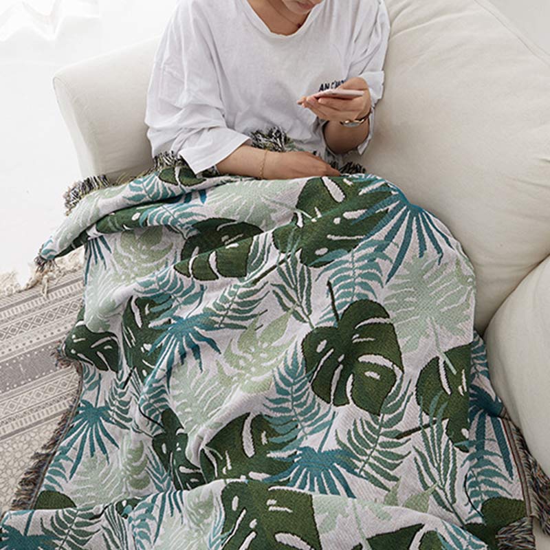 Copridivano con motivo a palma e coperta con nappe